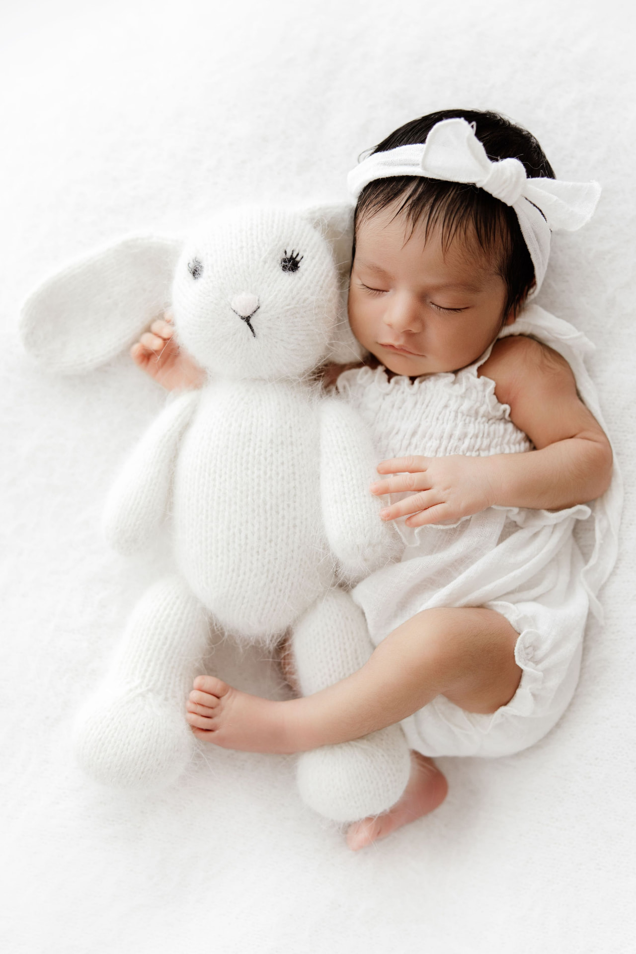 Newborn asleep with a soft white bunny