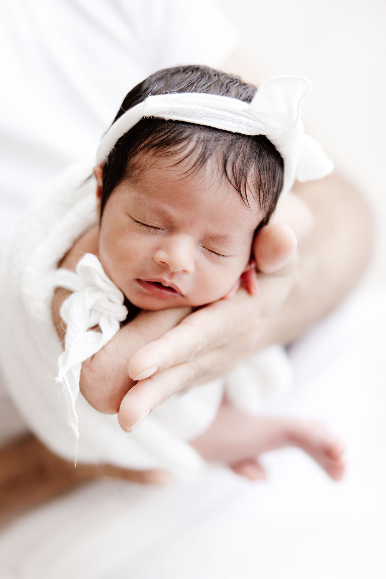 Newborn resting in her father's hands