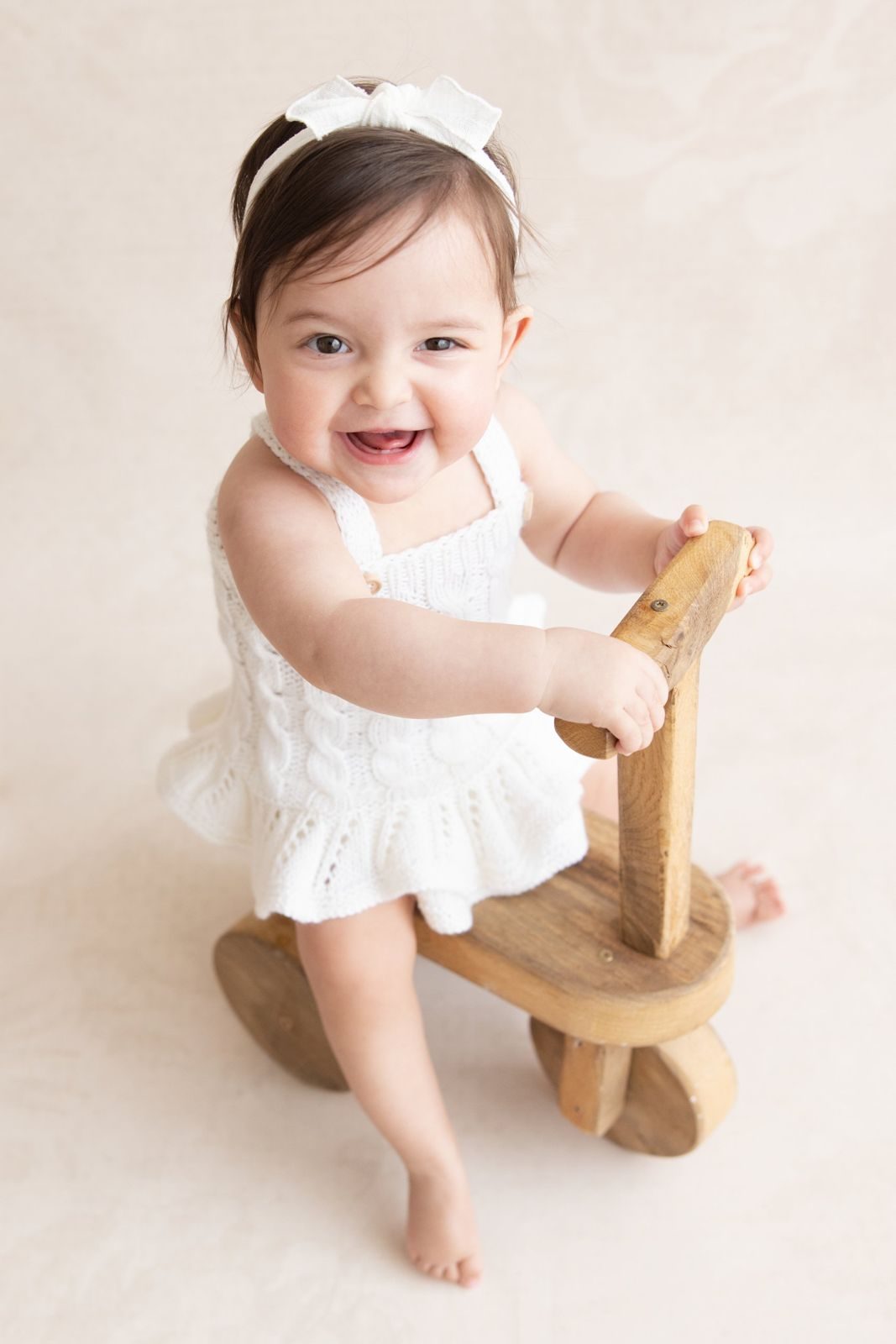 Laughing baby on a wooden balance bike