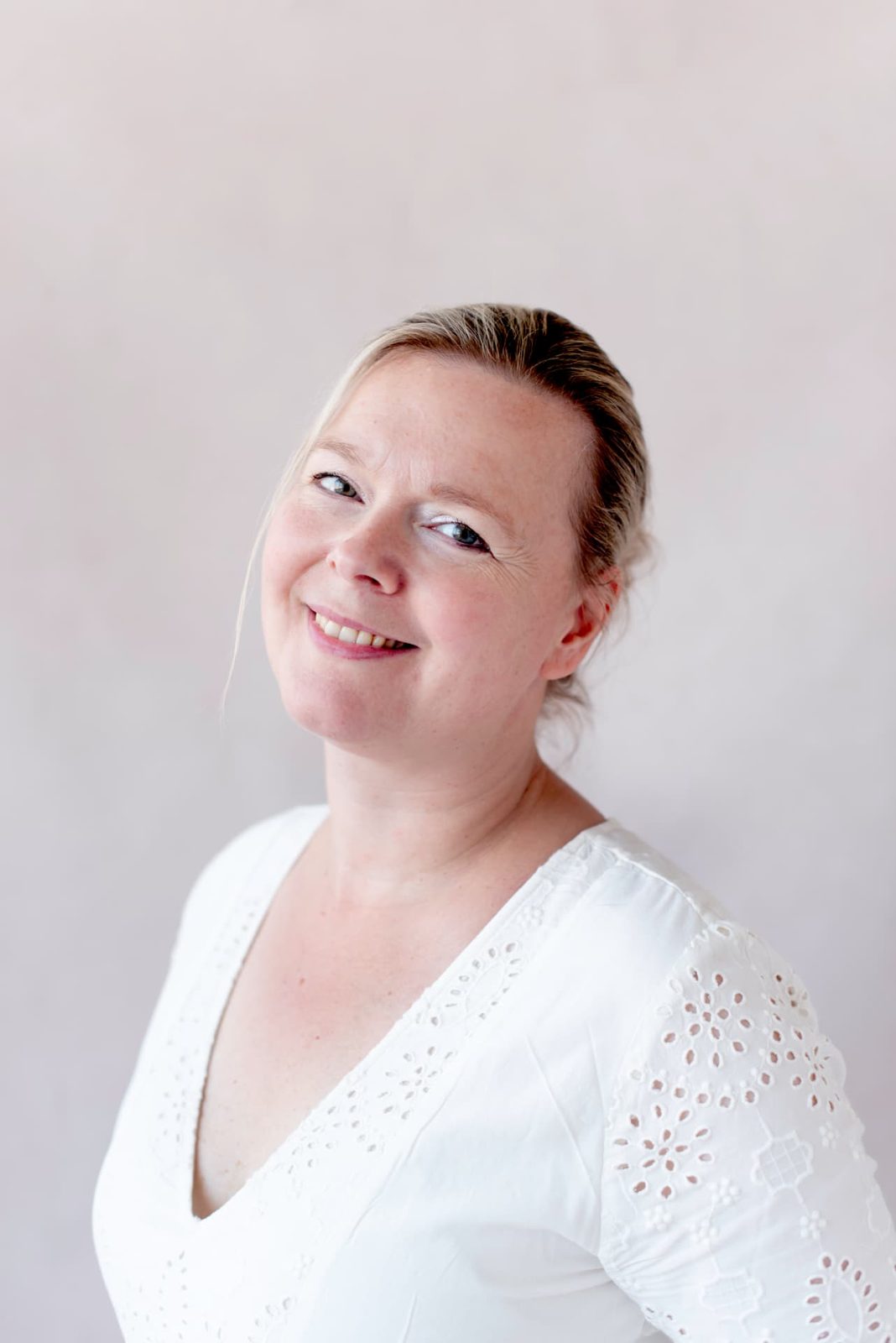 Brenda in a white dress, smiling at the camera