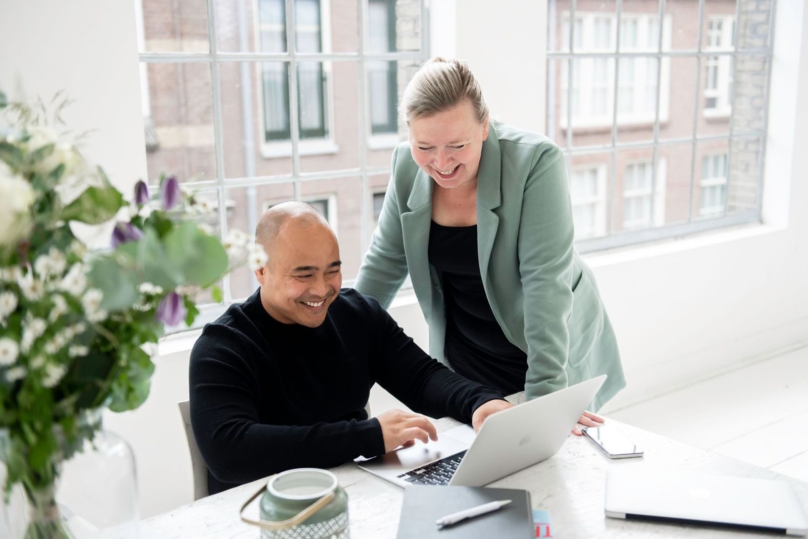 Brenda and Tam laughing together at the laptop