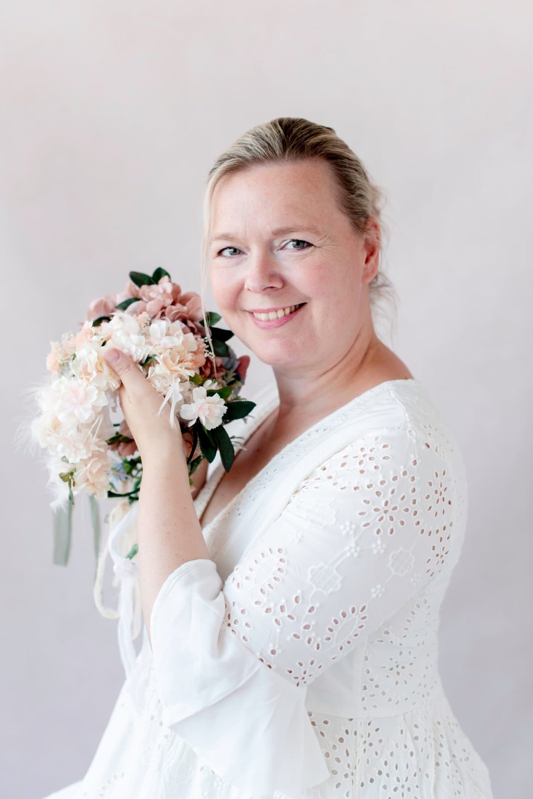 Brenda Olie smiling and holding a knitted floral crown