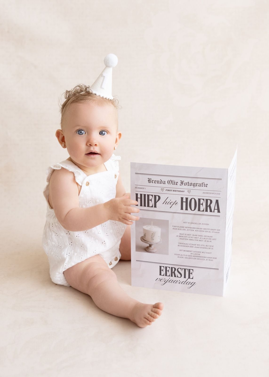 Baby girl with a party hat at her first birthday session
