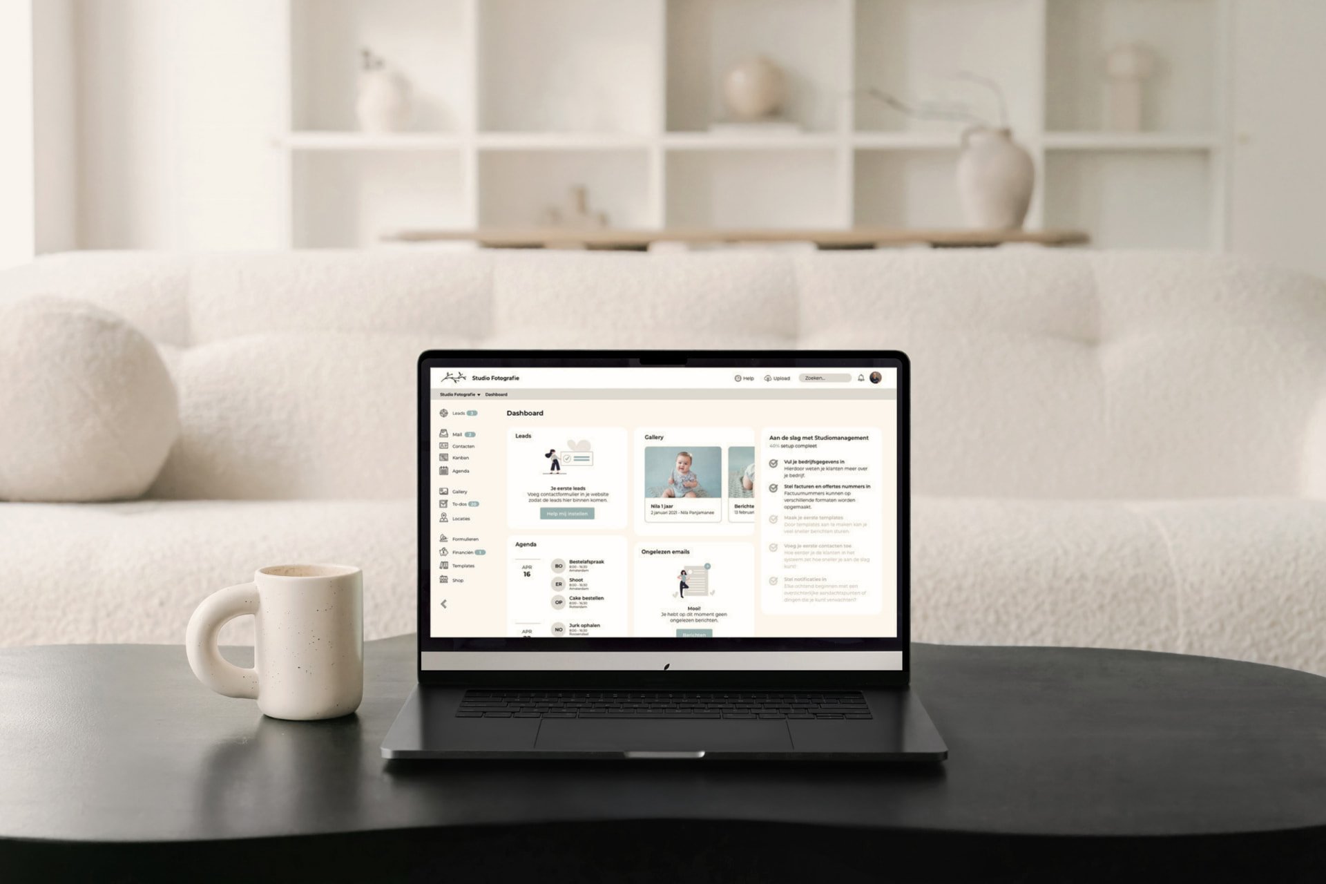 Studio Management dashboard on a laptop in a calm white living room