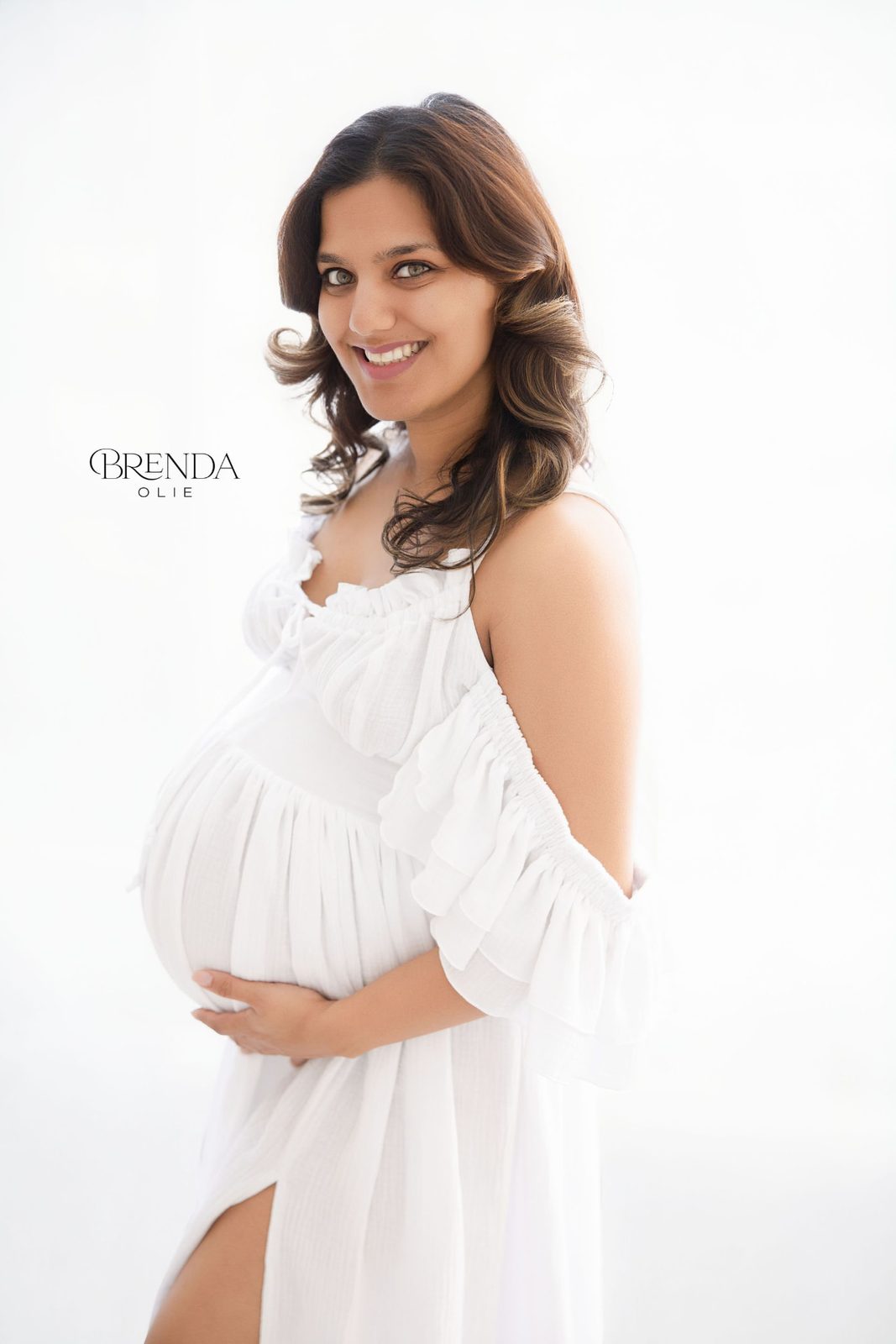 Expecting mother cradling her baby bump in soft daylight
