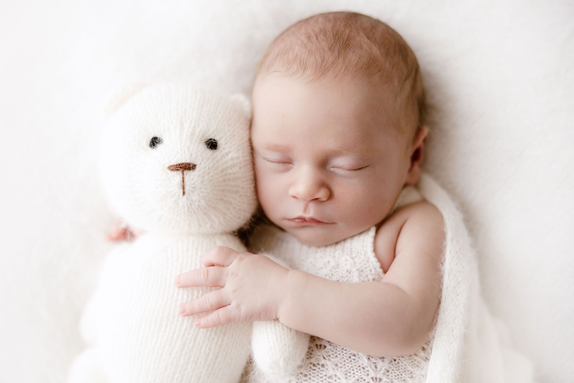 Newborn asleep next to a knitted bunny