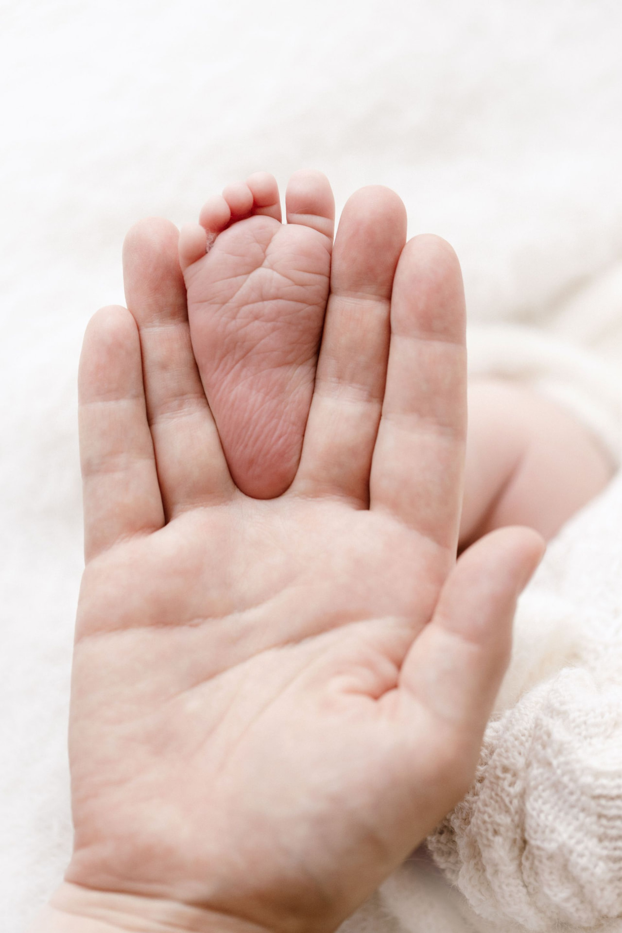 Tiny foot resting on a mother's palm