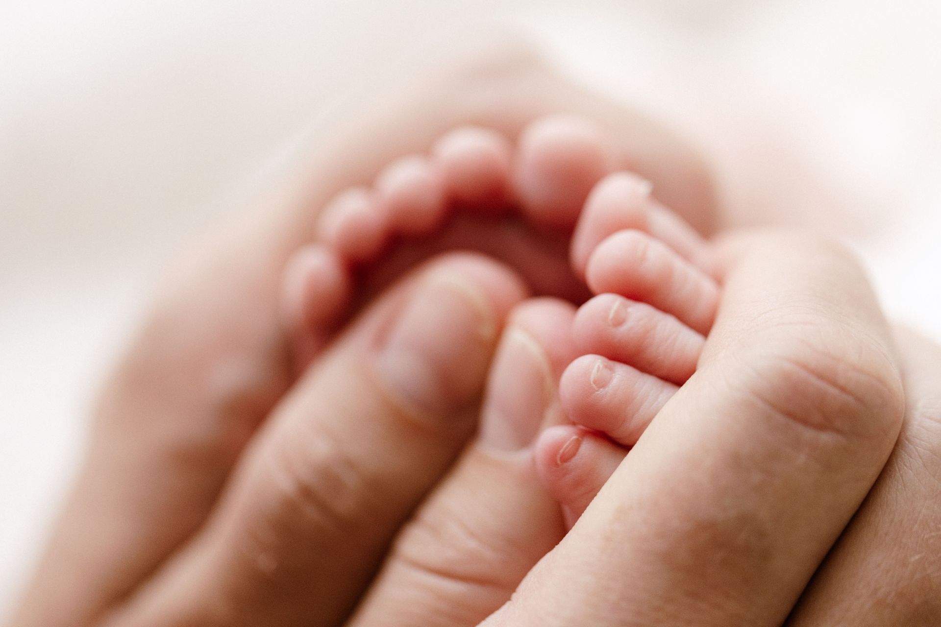 Tiny toes held in a mother's hand